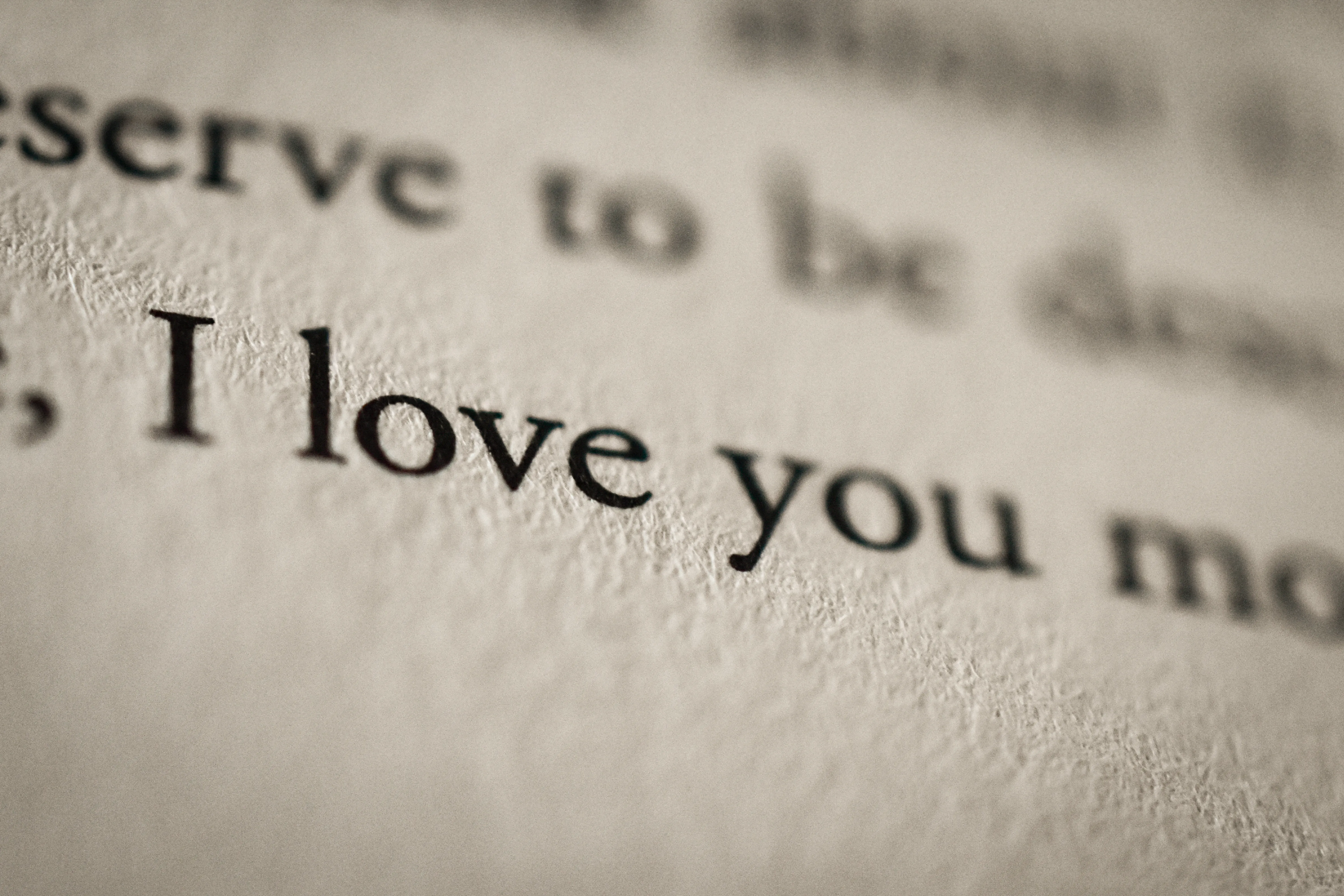 Close up of a paper book with the text "I love you" written on the page.